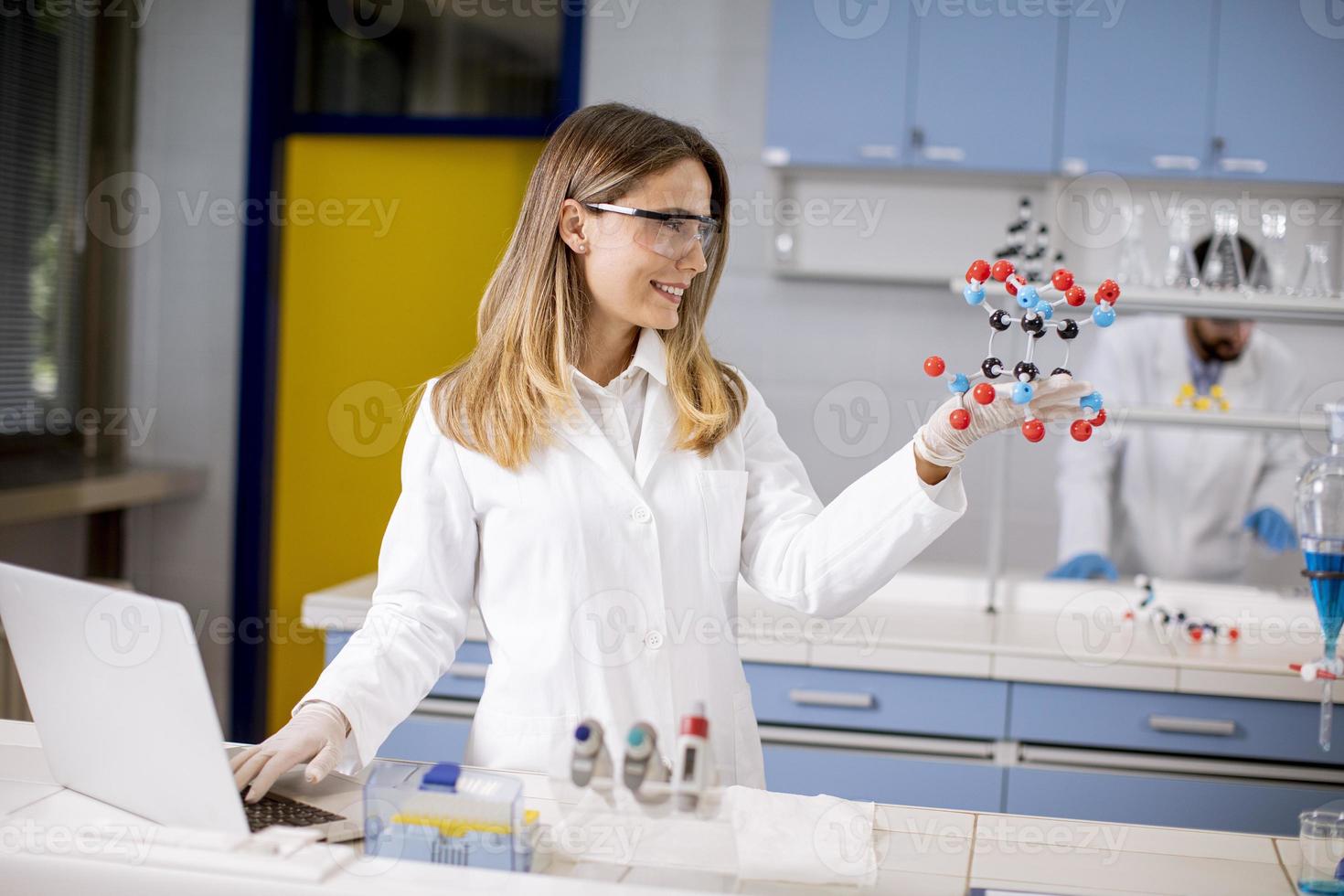 chimico femminile tenere il modello molecolare in laboratorio foto