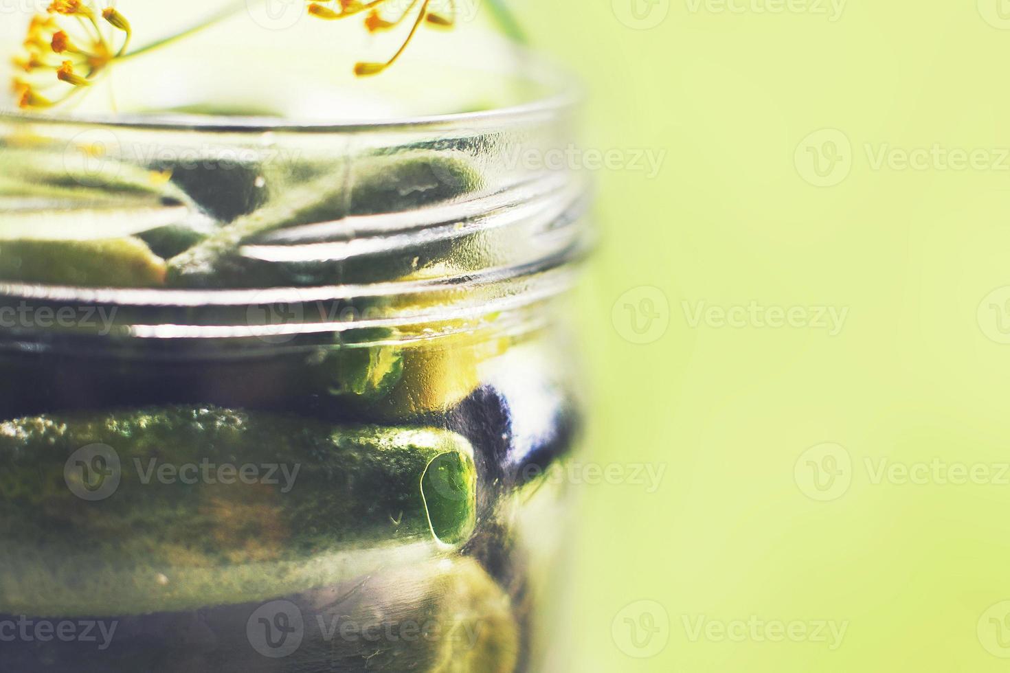 sottaceto cetrioli con aneto nel un' bicchiere barattolo. cetriolini cetrioli su un' verde sfondo. foto