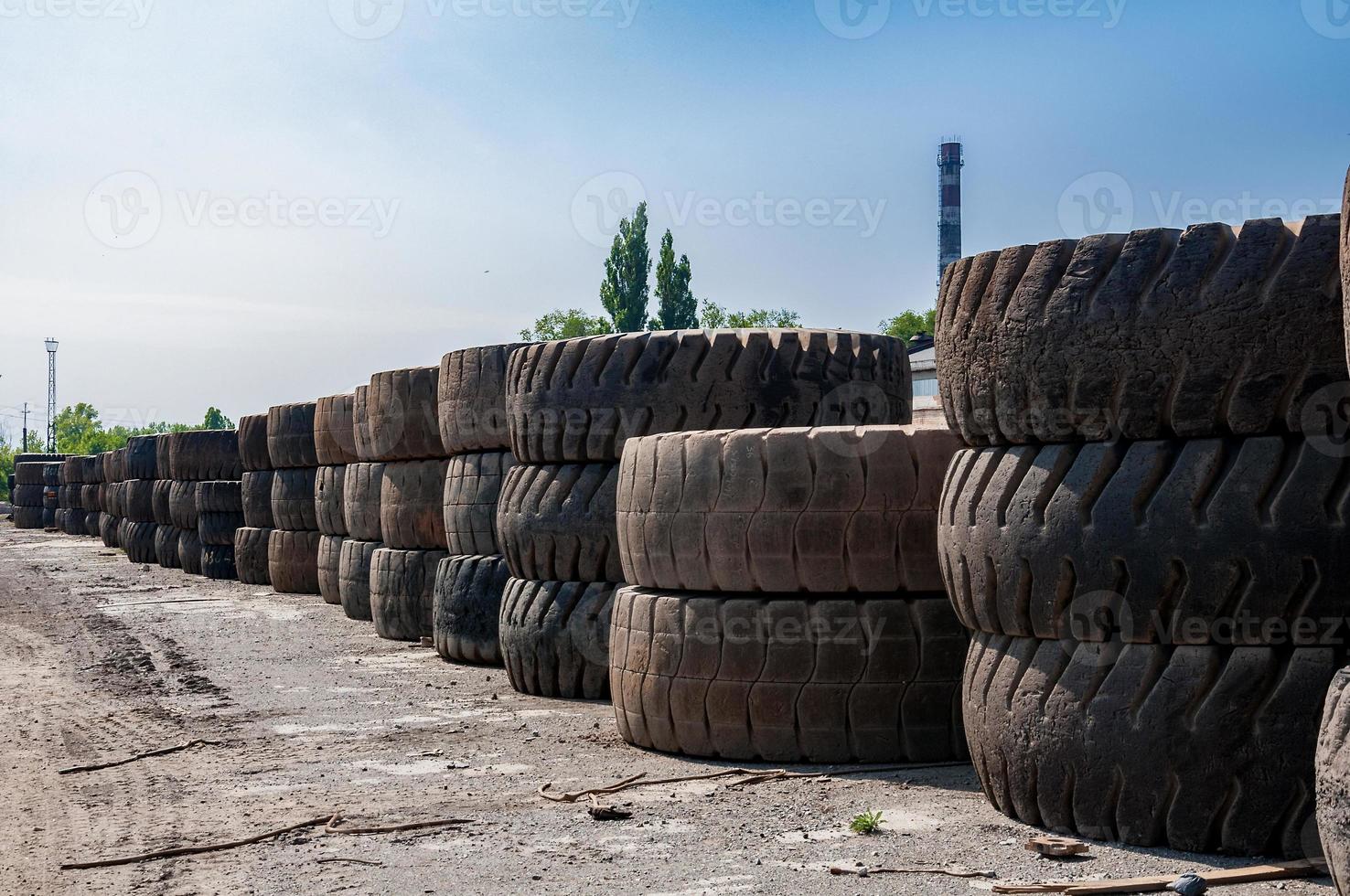 pila di un vecchio cava camion pneumatici su industriale rifiuto terra a soleggiato giorno foto