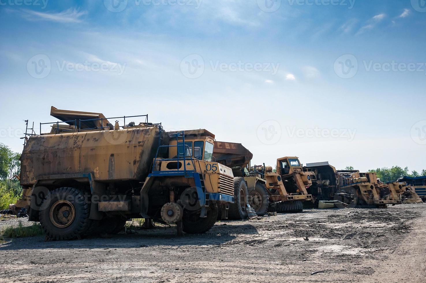 resti di vecchio cava camion e macchinari su Rifiuto cortile a soleggiato giorno foto