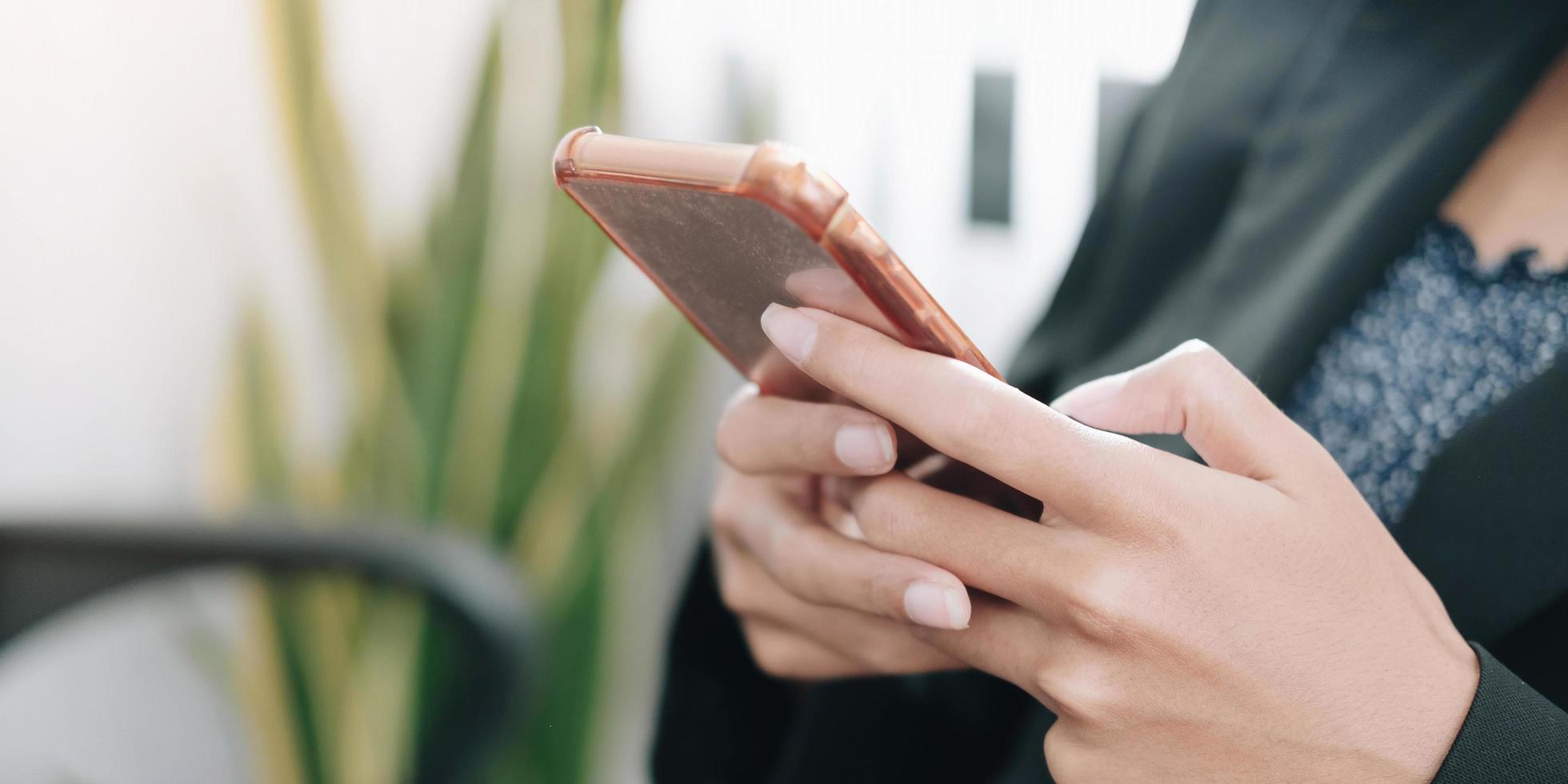 primo piano di una donna che utilizza uno smartphone foto