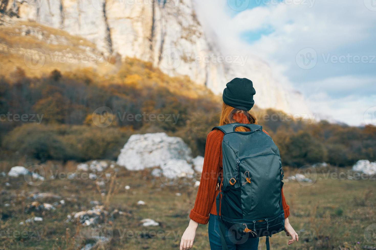 donna con un' zaino passeggiate su natura nel il montagne nel autunno blu cielo rocce paesaggio foto