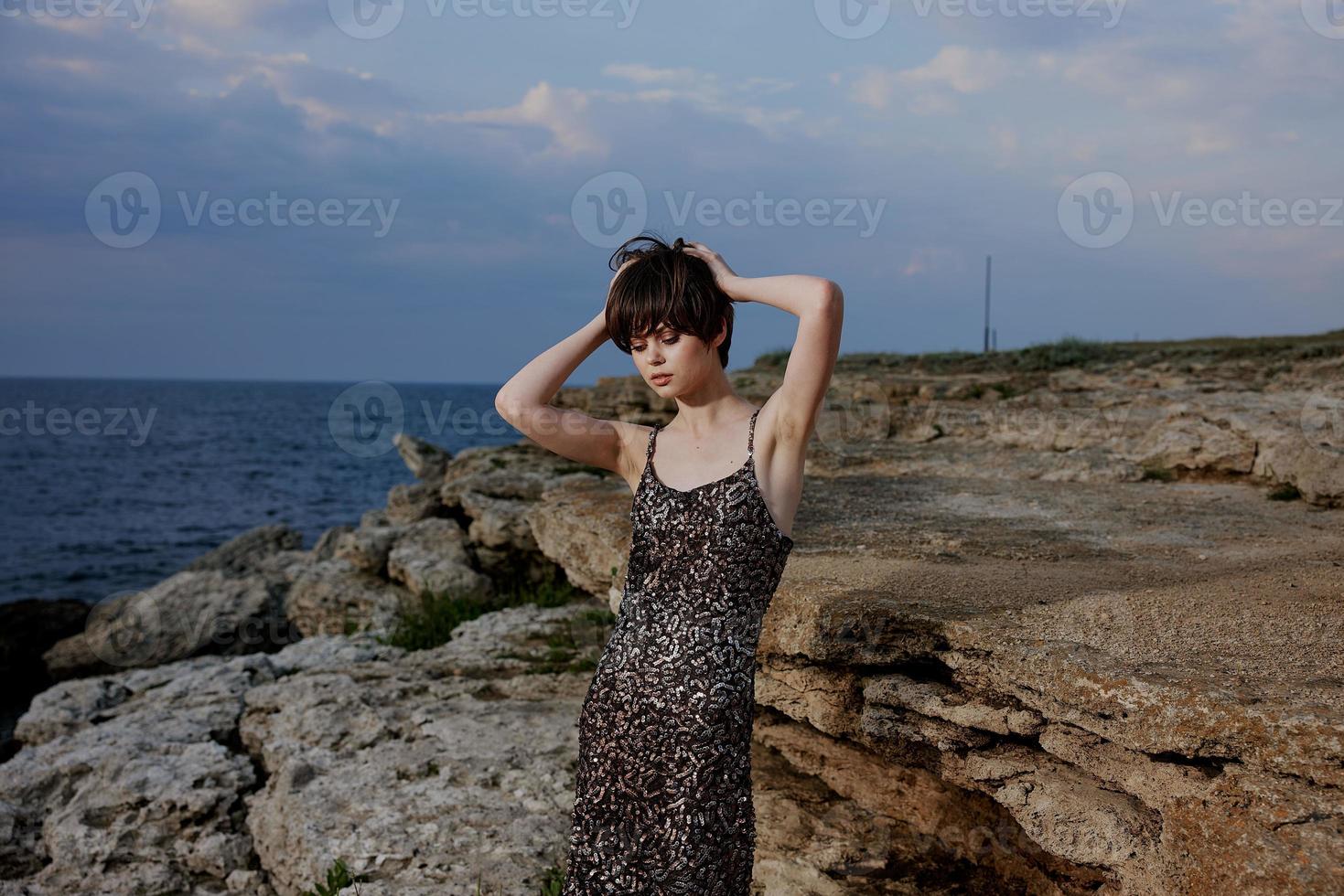 donna corto dai capelli erogazione spiaggia pietre natura foto