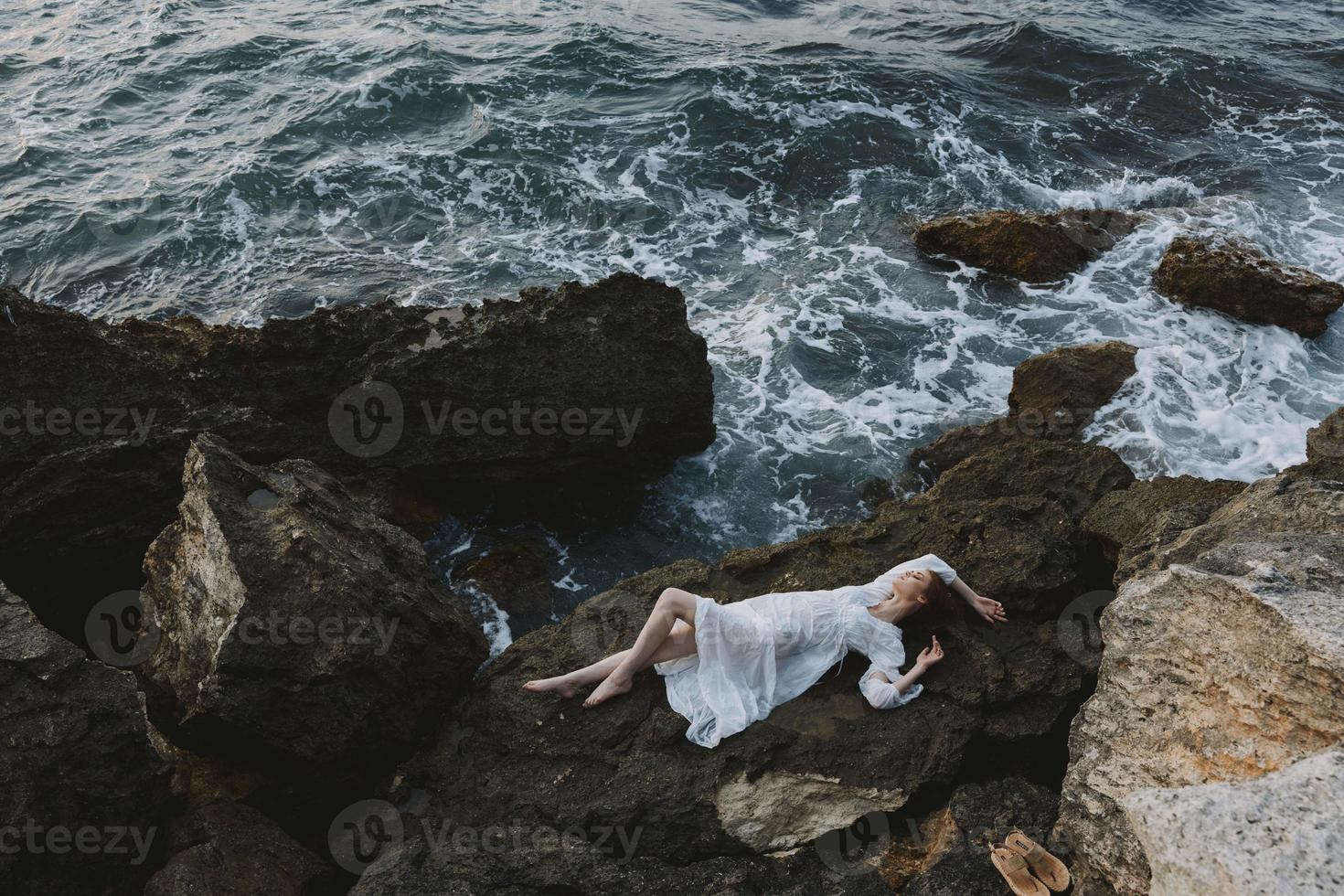 bellissimo sposa nel un' appartato individuare su un' selvaggio roccioso costa nel un' bianca vestito inalterato foto