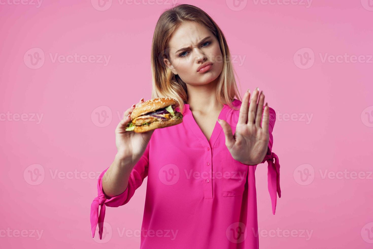 carino allegro donna nel rosa camicia Hamburger cibo dieta foto