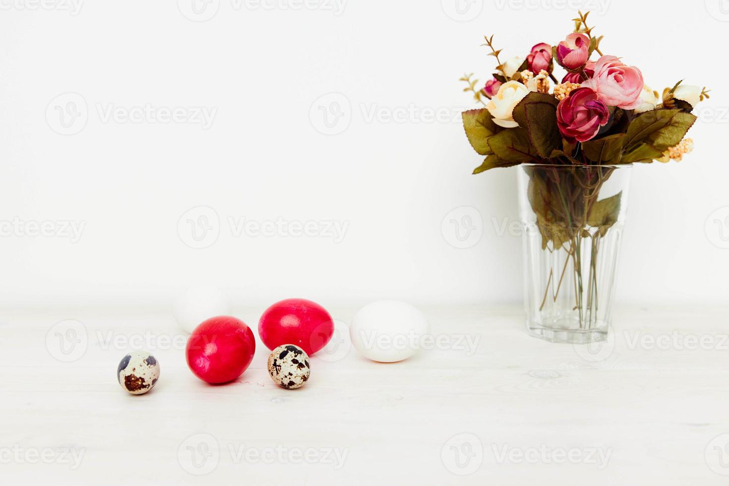 mazzo di fiori e luminosa Pasqua uova su il tavolo foto
