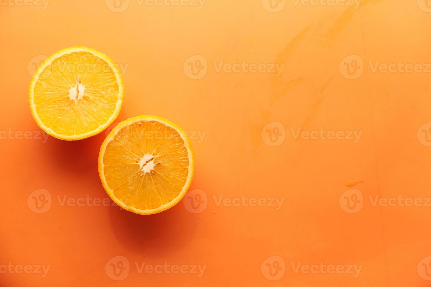 arancia a fette su uno sfondo arancione foto