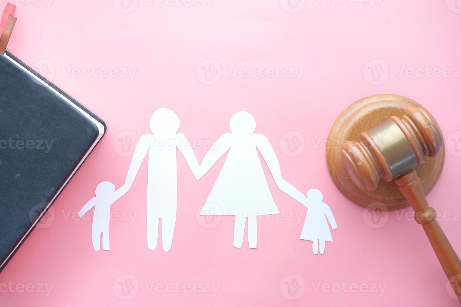 ritaglio di carta di una famiglia su uno sfondo rosa con un martelletto foto