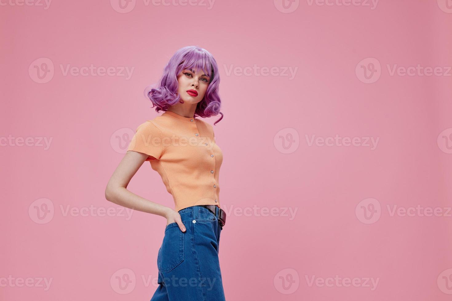 bella affascinante donna viola capelli nel jeans rosa sfondo foto
