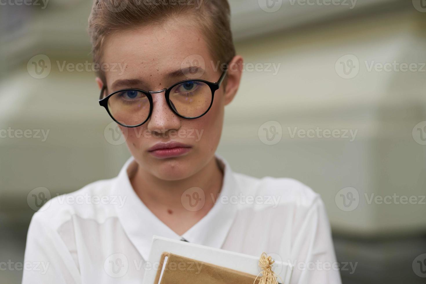 alunno con bicchieri a piedi in giro il città con un' libro formazione scolastica foto