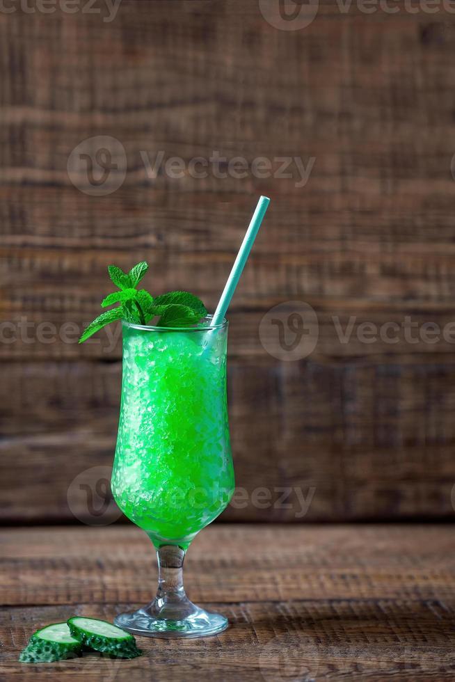 estate siciliano granito dolce, congelato succo di fresco cetriolo e menta nel un' alto bicchiere su un' di legno sfondo, minimalismo. estate freddezza, Tonico schiacciato ghiaccio cocktail foto