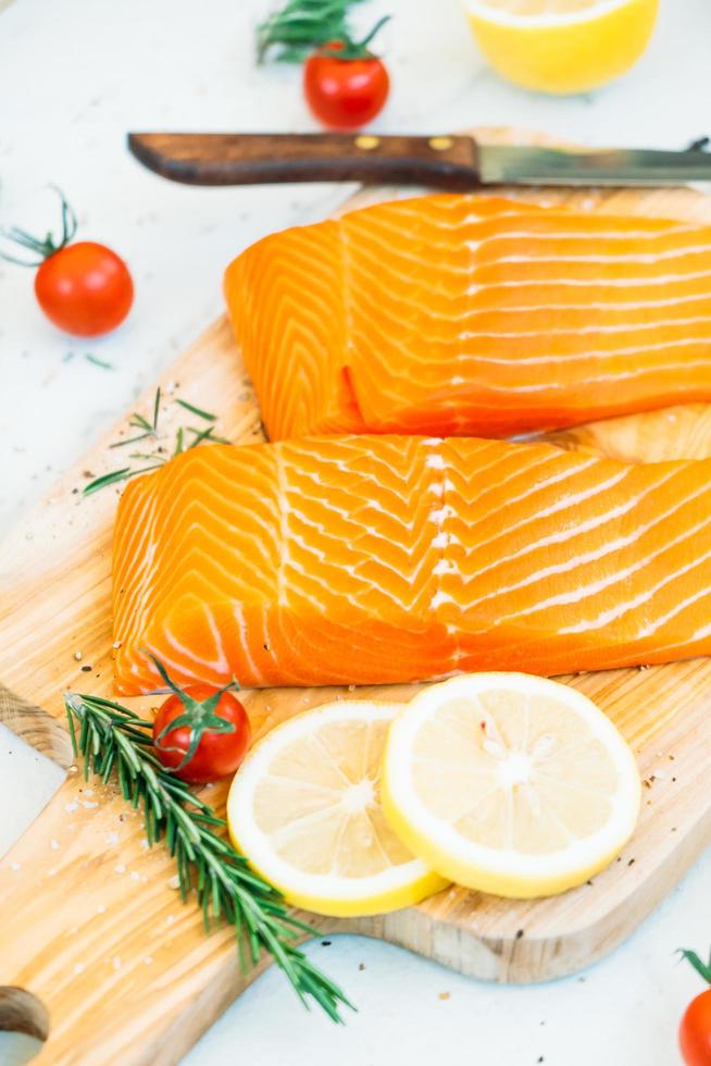 filetto di carne di salmone crudo e fresco sul tagliere di legno foto