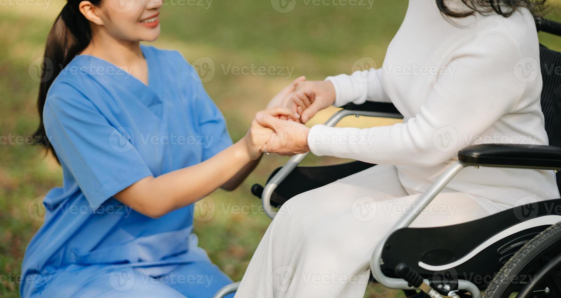 anziano asiatico anziano donna su sedia a rotelle con asiatico attento Caregiver. assistenza infermieristica casa ospedale giardino concetto. nel sole leggero foto