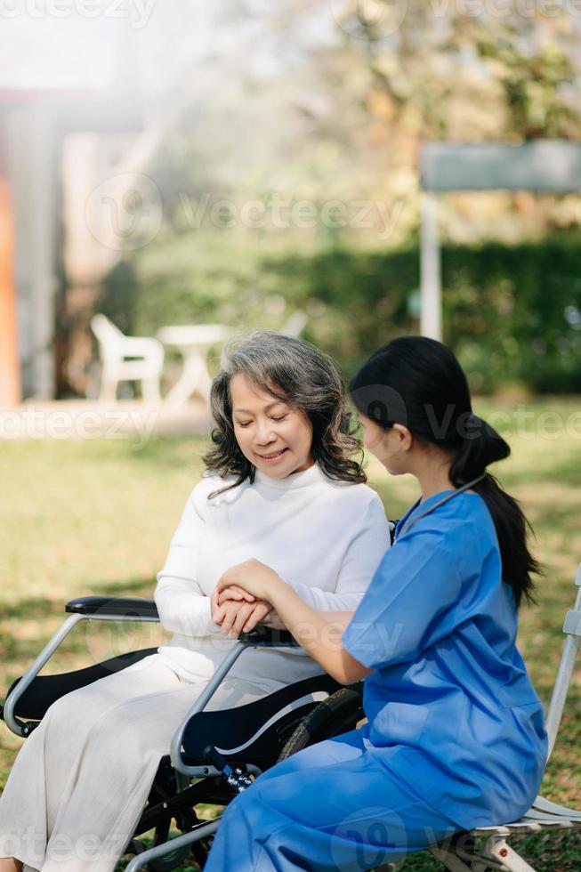 asiatico femmina mani toccante vecchio femmina mano porzione mani prendere cura di il anziano concetto nel parco ospedale foto