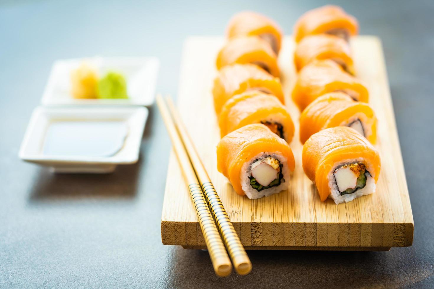salmone pesce carne sushi roll maki sul piatto di legno foto