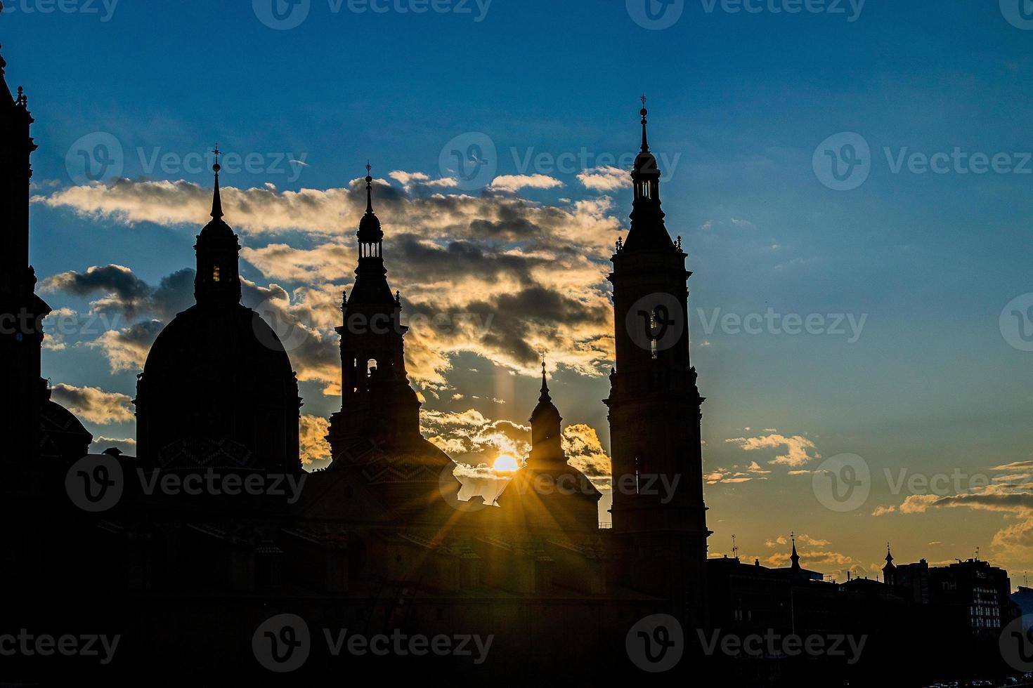 urbano tramonto al di sopra di il Pilar Cattedrale nel saragozza, Spagna e il ebro fiume foto