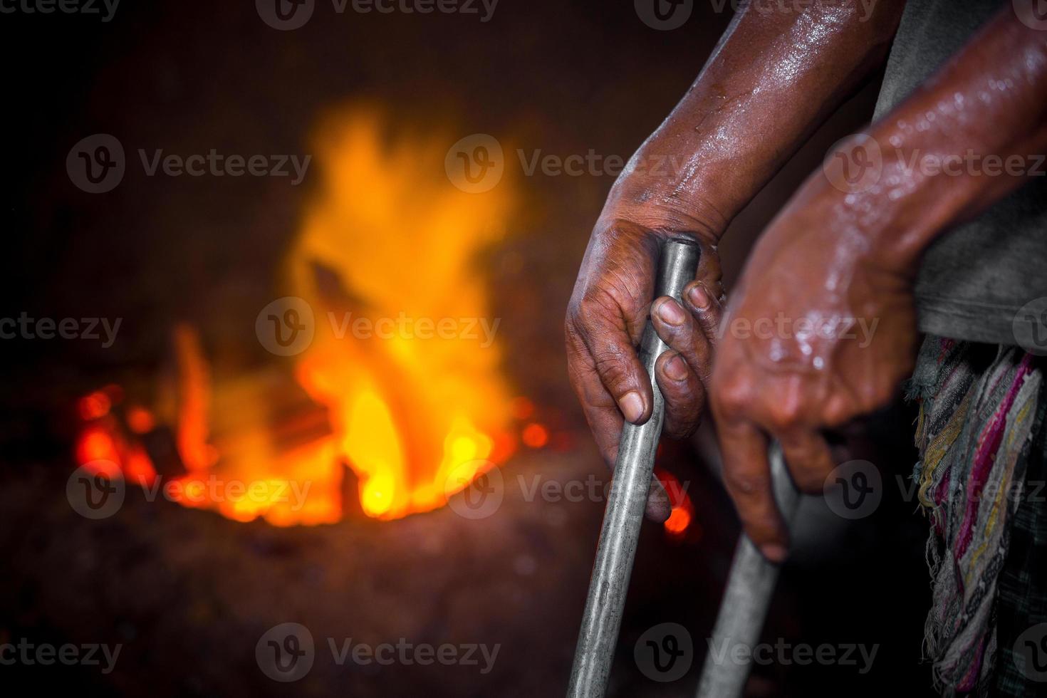 pericoloso lavoratore mani. un' Locale acciaio macchina parti fabbricazione cortile lavoratore fusione rottame su caldo forno. foto