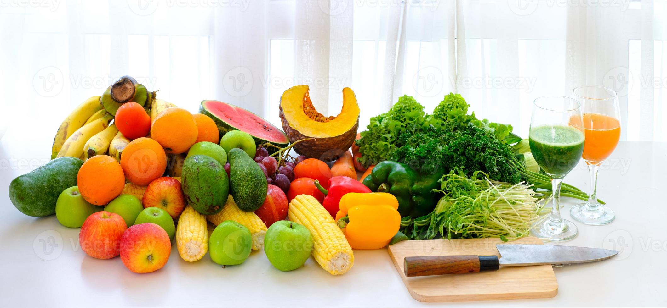 assortiti freschi maturi di frutta e verdura sul tavolo con sfondo bianco tenda foto