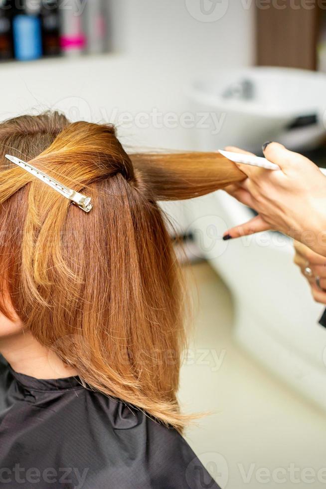 il femmina cliente ricevente un' taglio di capelli a il bellezza salone, giovane donna godendo ottenere un' nuovo acconciatura. foto