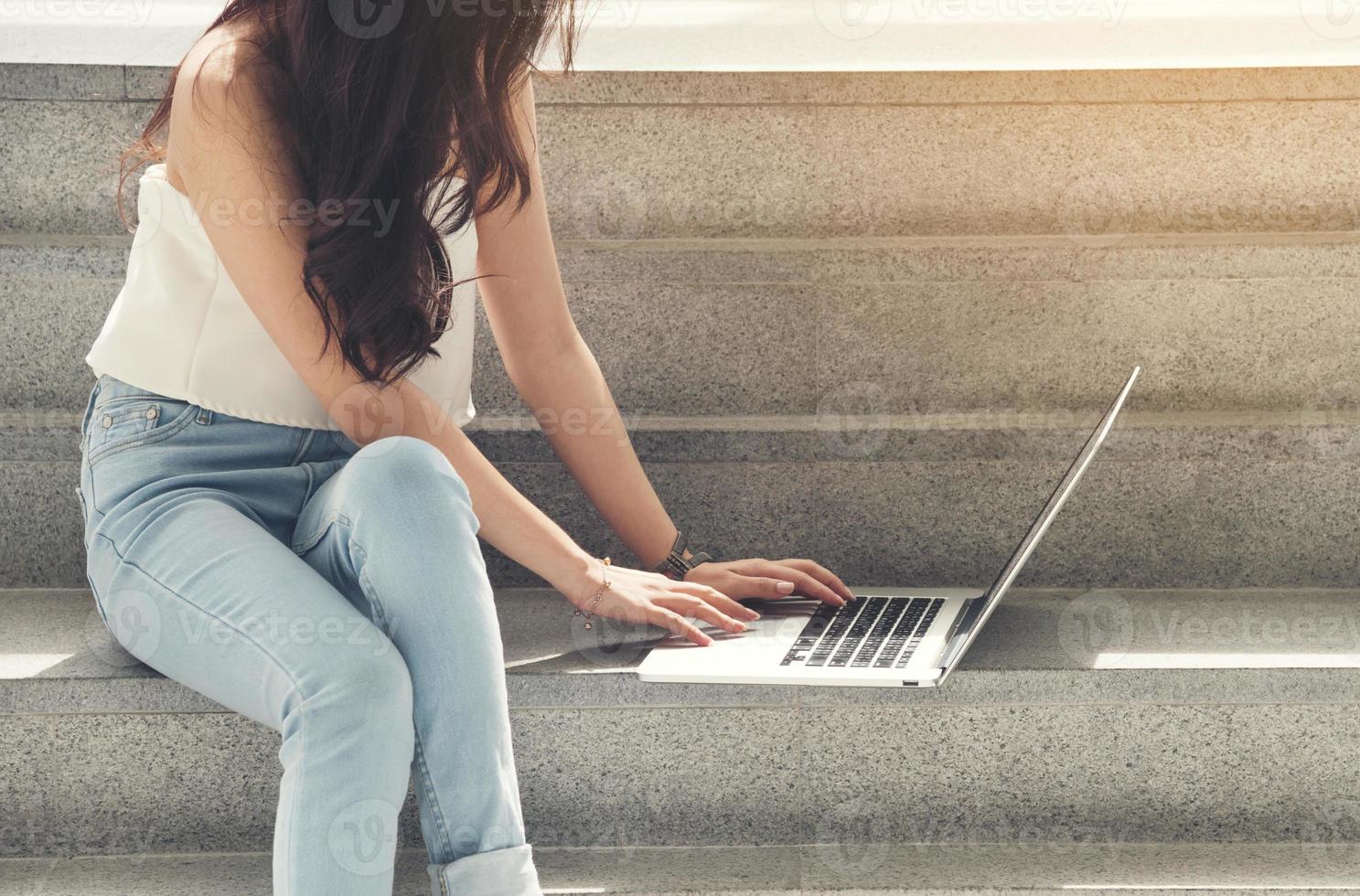 primo piano della donna che utilizza computer portatile all'esterno foto