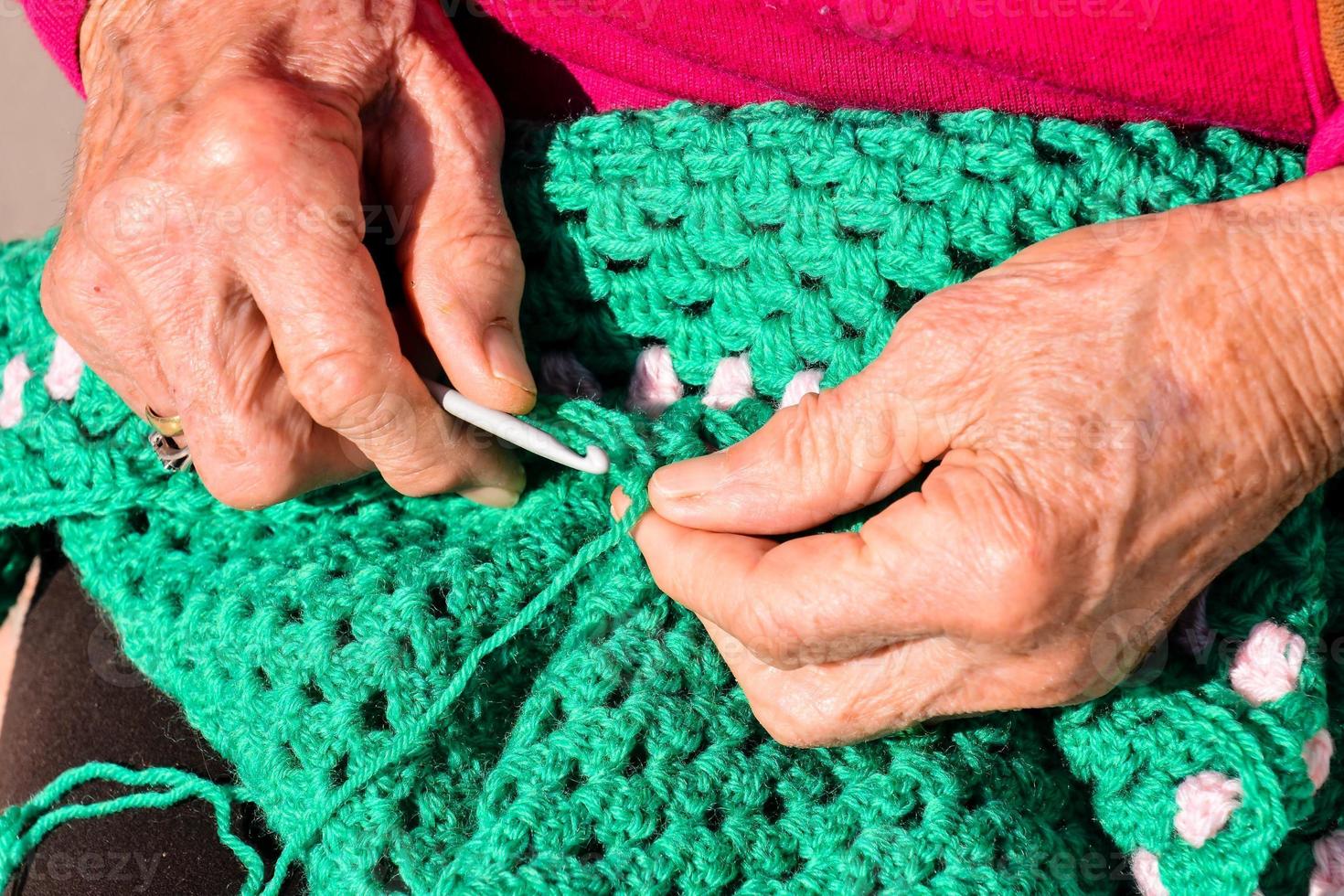 vecchio donna con maglieria aghi e lana foto