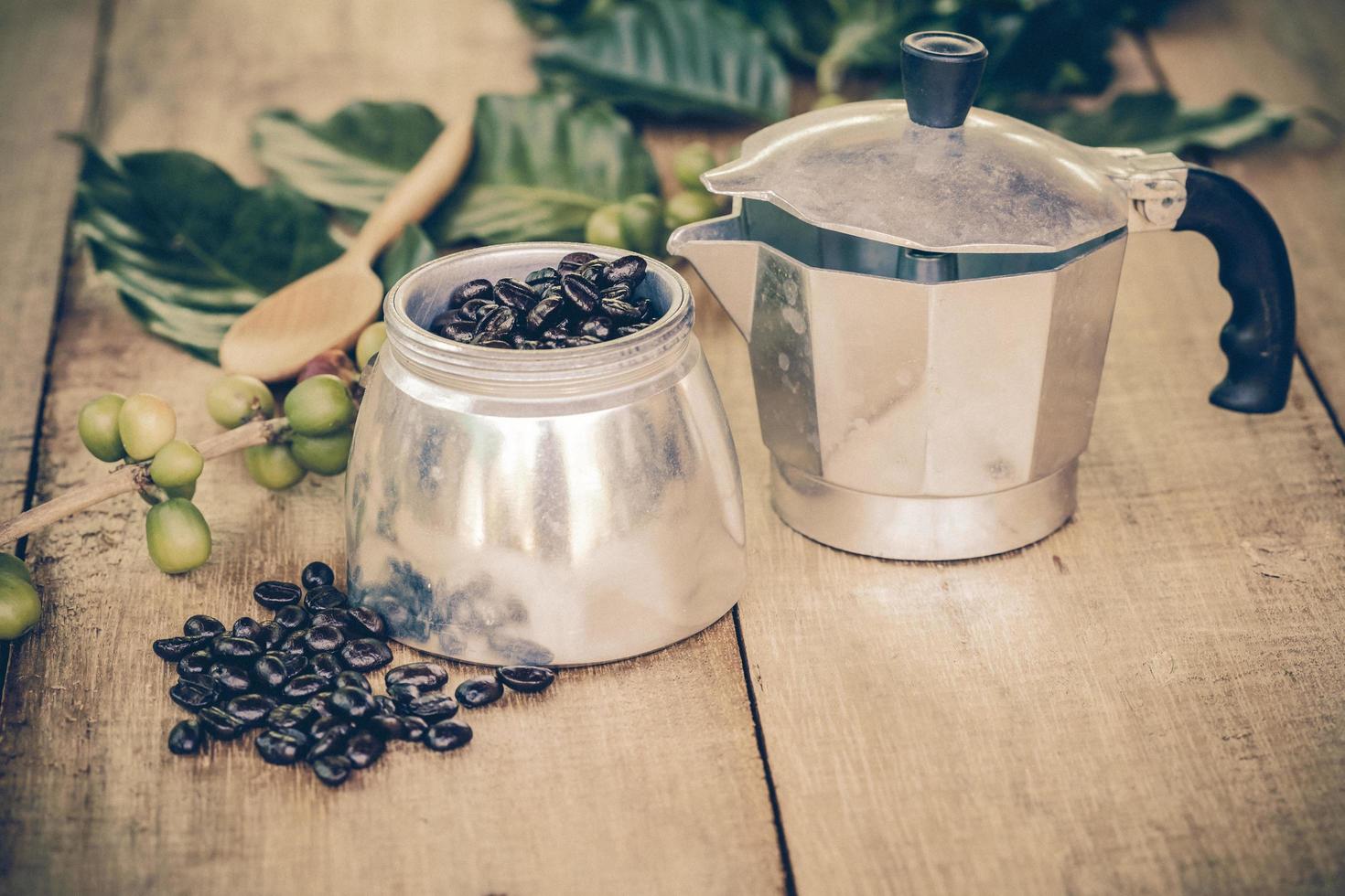 fresco caffè fagioli su legna con un' moga pentola foto