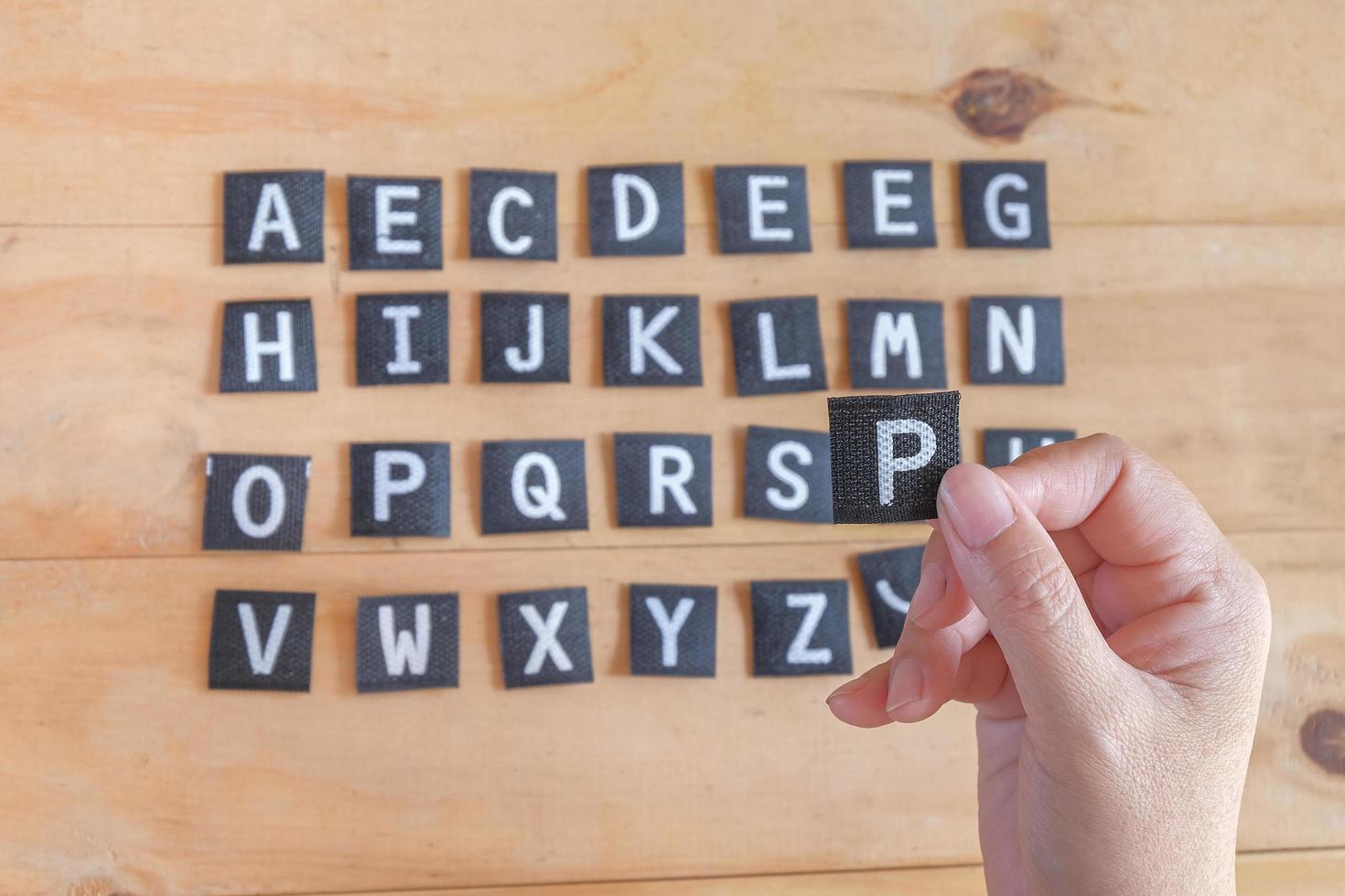 mano hold un' inglese alfabeto lettere . foto