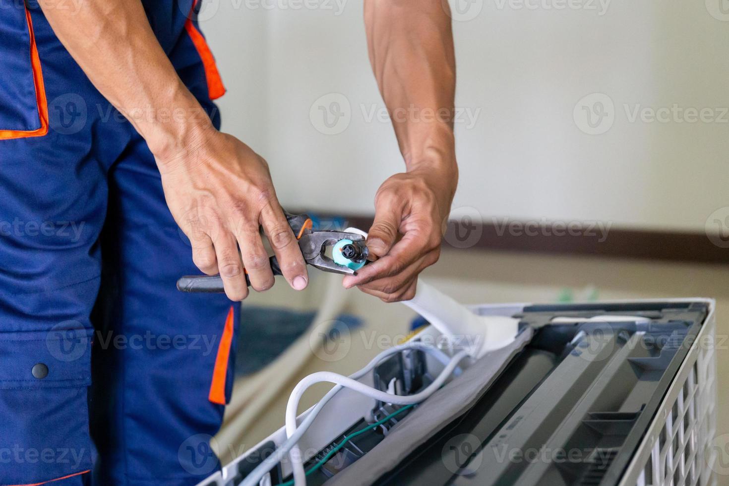tecnico uomo installazione un aria condizionata nel un' cliente Casa, giovane riparatore fissaggio aria condizionatore unità, Manutenzione e riparazione concetti foto