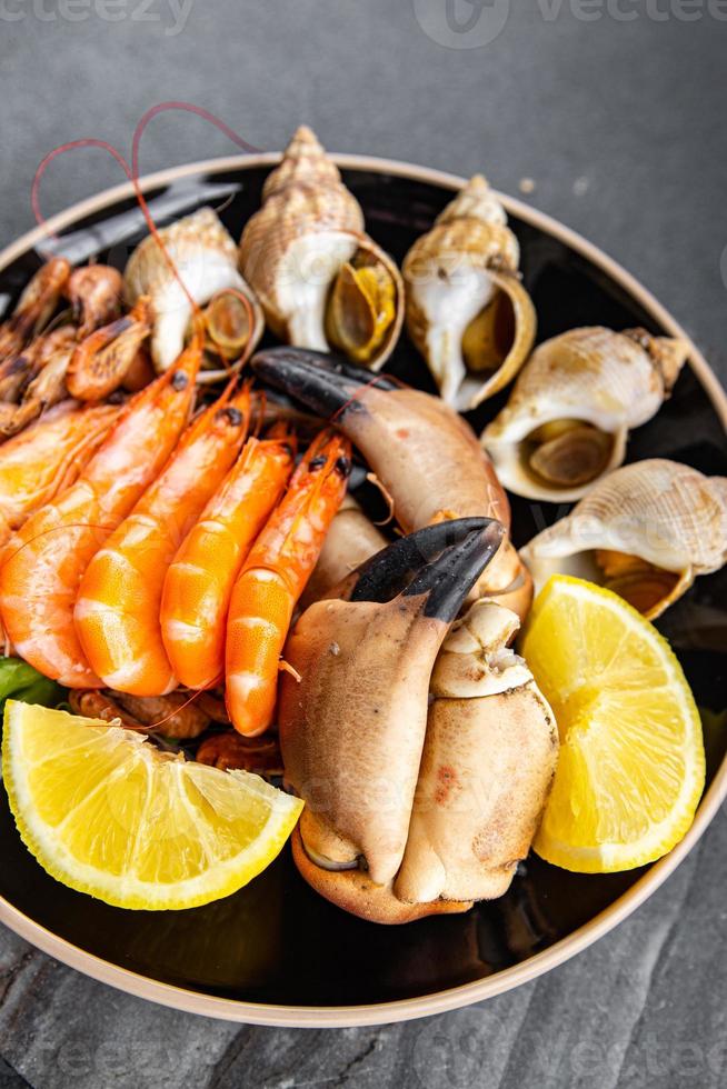 frutti di mare piatto assortito gamberetti, Granchio artigli, vongole, rapano, trombettista mollusco pasto cibo merenda su il tavolo copia spazio cibo sfondo rustico superiore Visualizza foto