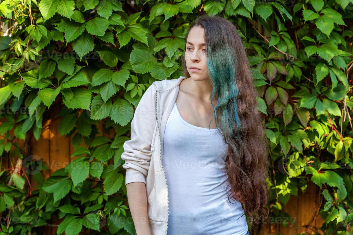 bellissimo giovane fricchettone bruna ragazza con lungo verde capelli sorridente su parco sfondo foto