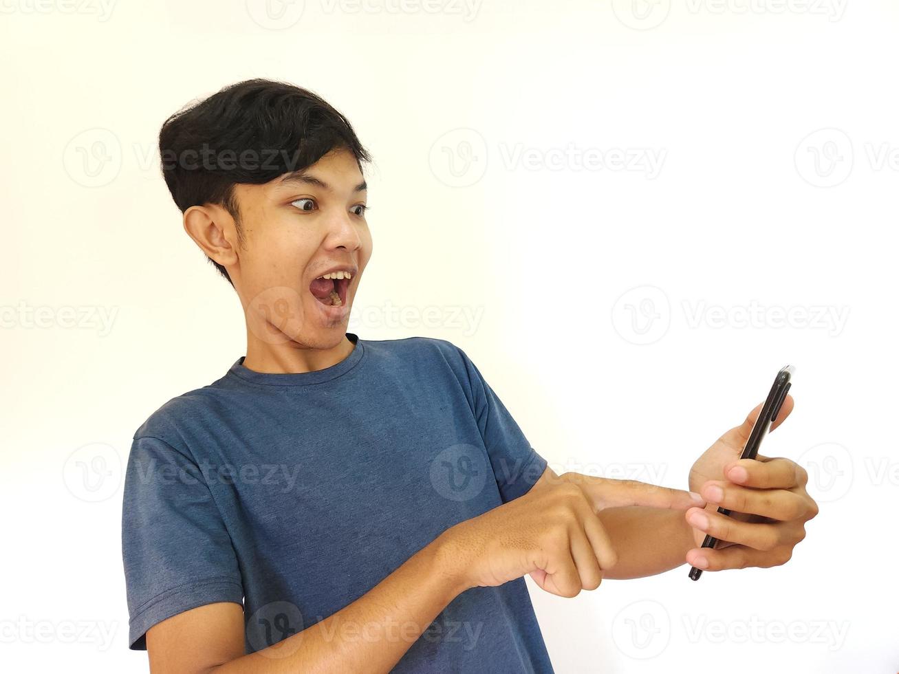 asiatico uomo essere shock e sorpreso dopo Guardando a partire dal smartphone foto