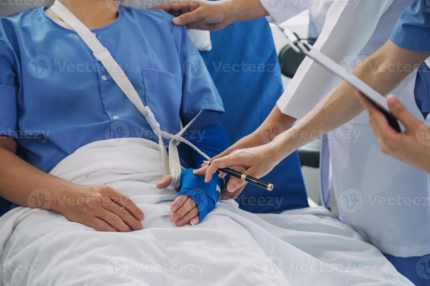 ferito paziente mostrando medico rotto polso e braccio con bendare nel ospedale ufficio o emergenza camera. distorsione, fatica frattura o ripetitivo sforzo infortunio nel mano. infermiera porzione cliente. primo aiuto. foto