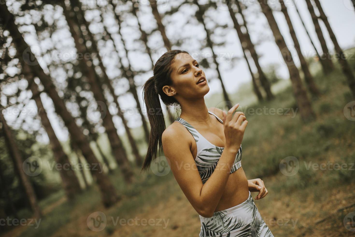 giovane donna fitness in esecuzione al sentiero nel bosco foto