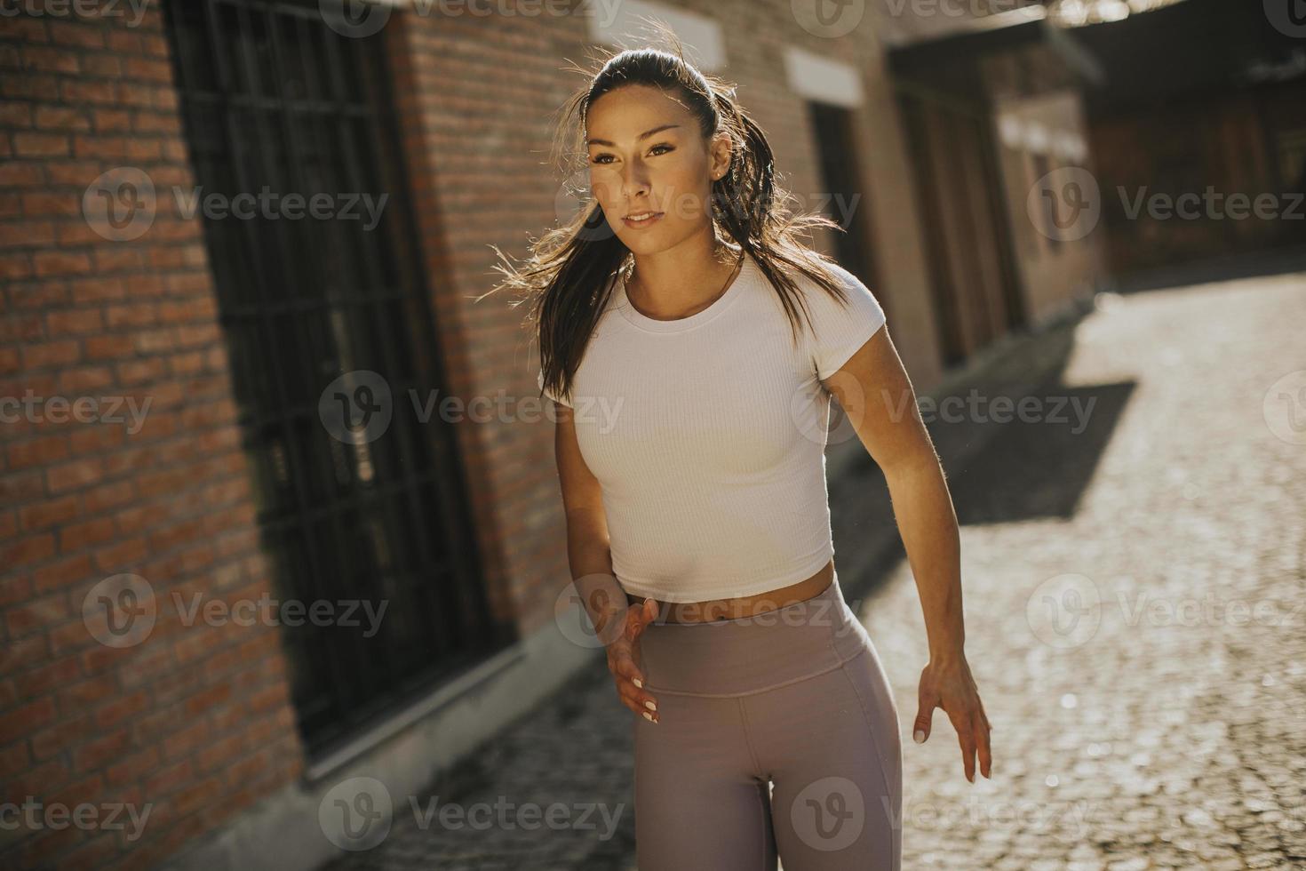 giovane donna che corre sulla strada foto