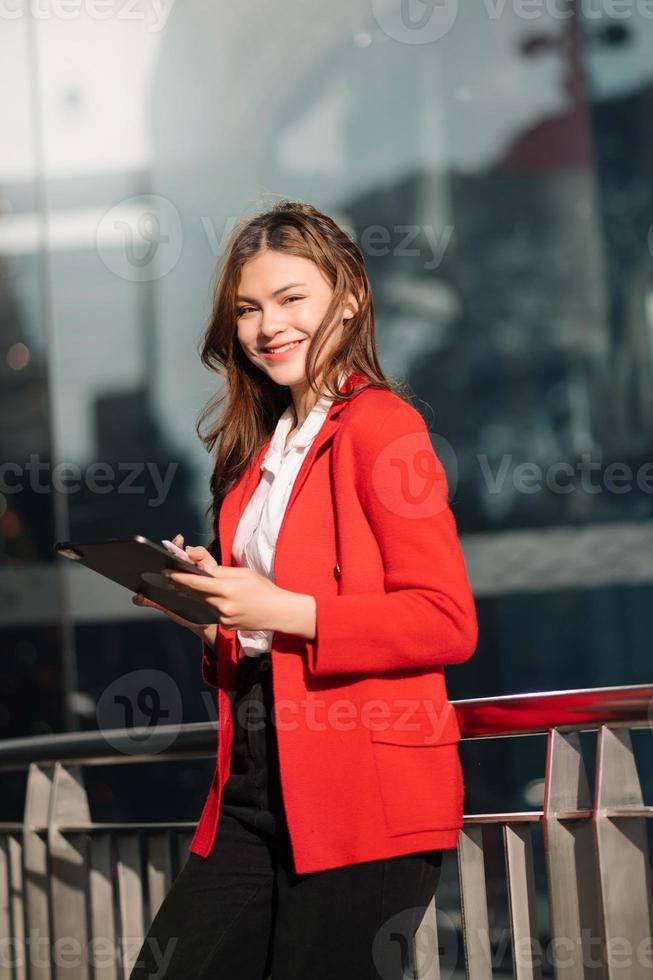 attività commerciale donna è Abbracciare una persona e Tenere un' il computer portatile e tavoletta nel davanti di un' edificio foto