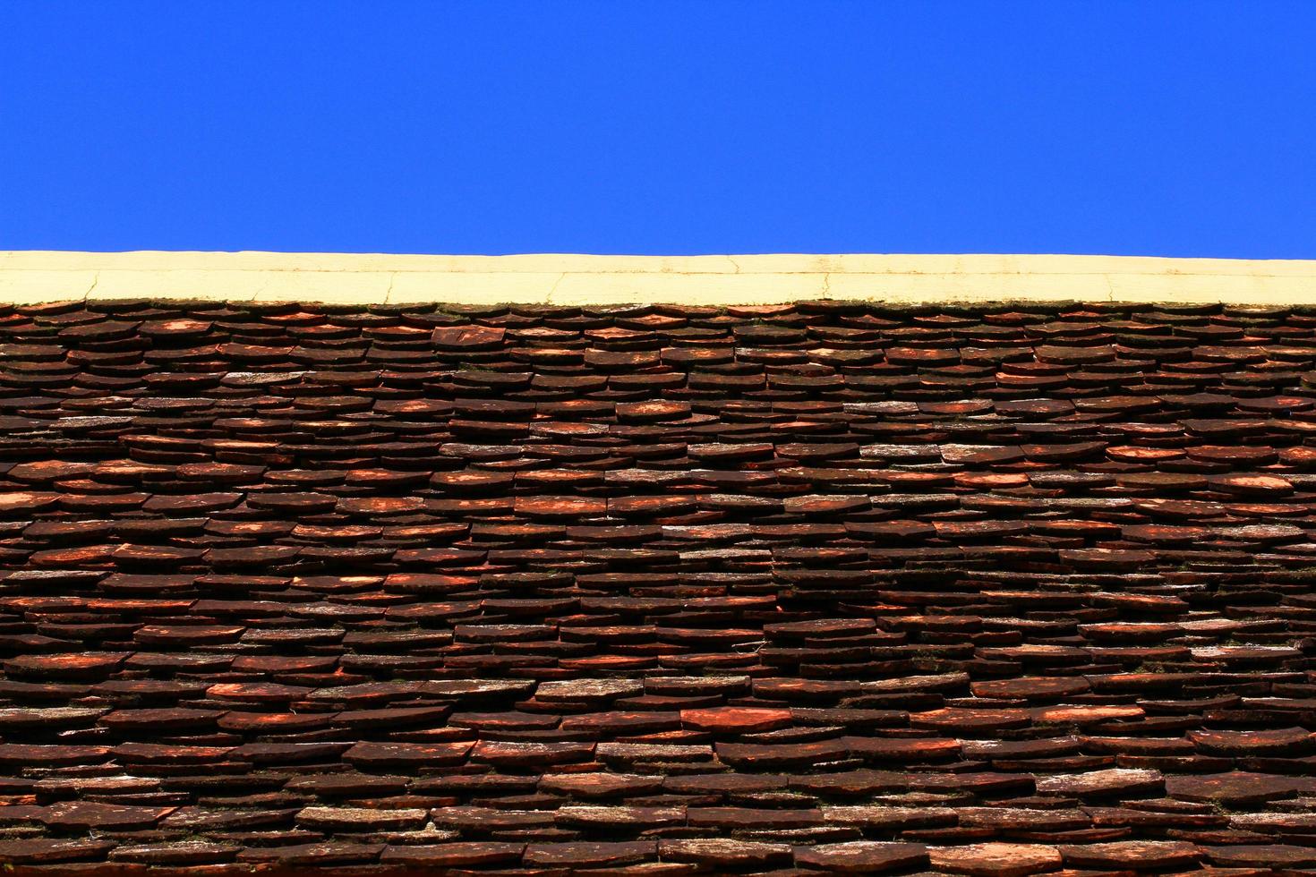 argilla piastrella arte tetto di buddista tempio nel blu cielo foto