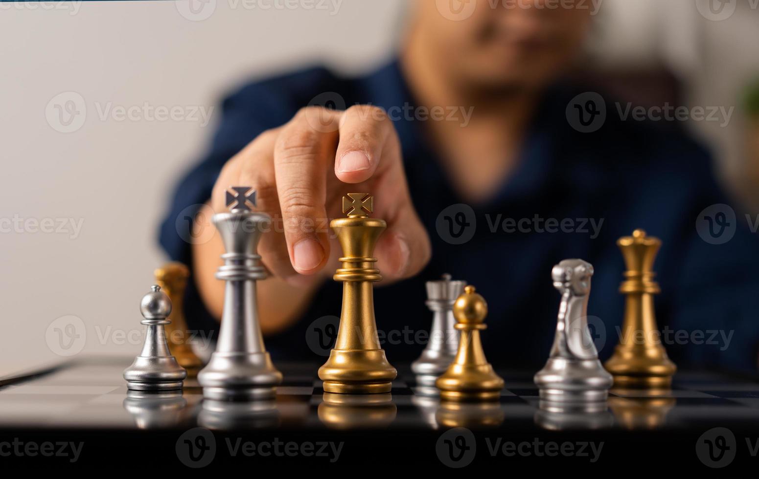 vicino su di mani di un' attività commerciale uomo in movimento re d'oro scacchi per la sconfitta avversario il scacchi gioco è sviluppo analisi, strategia, e Piano, il gestione o comando concetto. foto