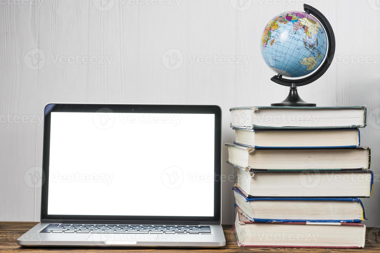 globo e libri vicino al computer portatile su un tavolo foto
