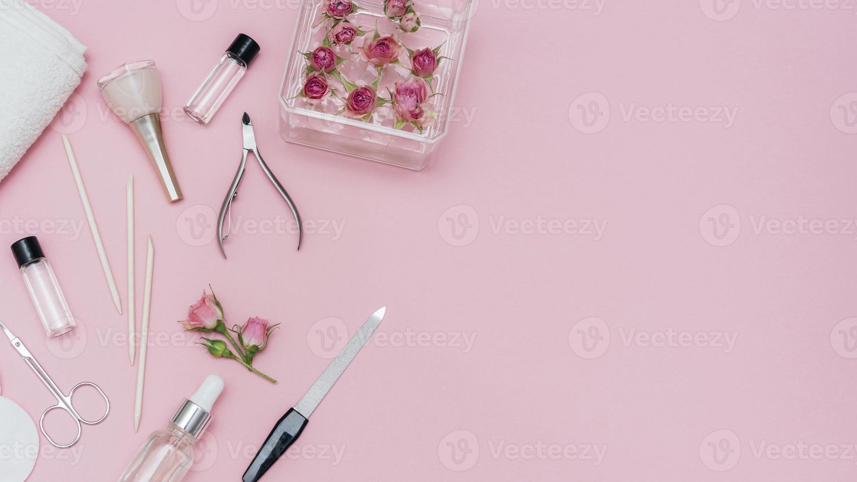 disposizione di accessori per la cura delle unghie su sfondo rosa foto
