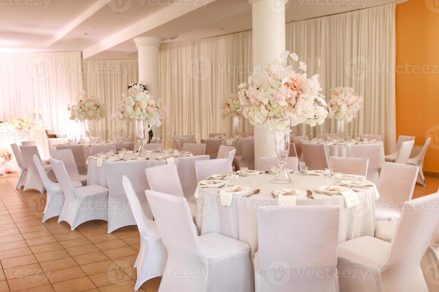 festivo nozze decorazione. bellissimo fresco bianca e rosa fiori nel bicchiere vaso su cenare tavolo su nozze giorno. alto qualità foto