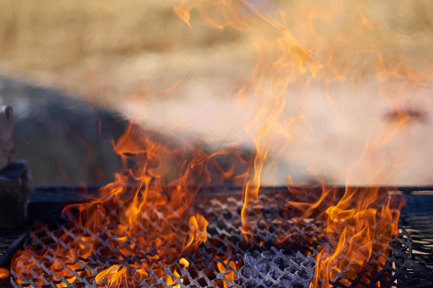 fuoco in una griglia vintage arrugginita all'aperto con sfondo sfocato foto