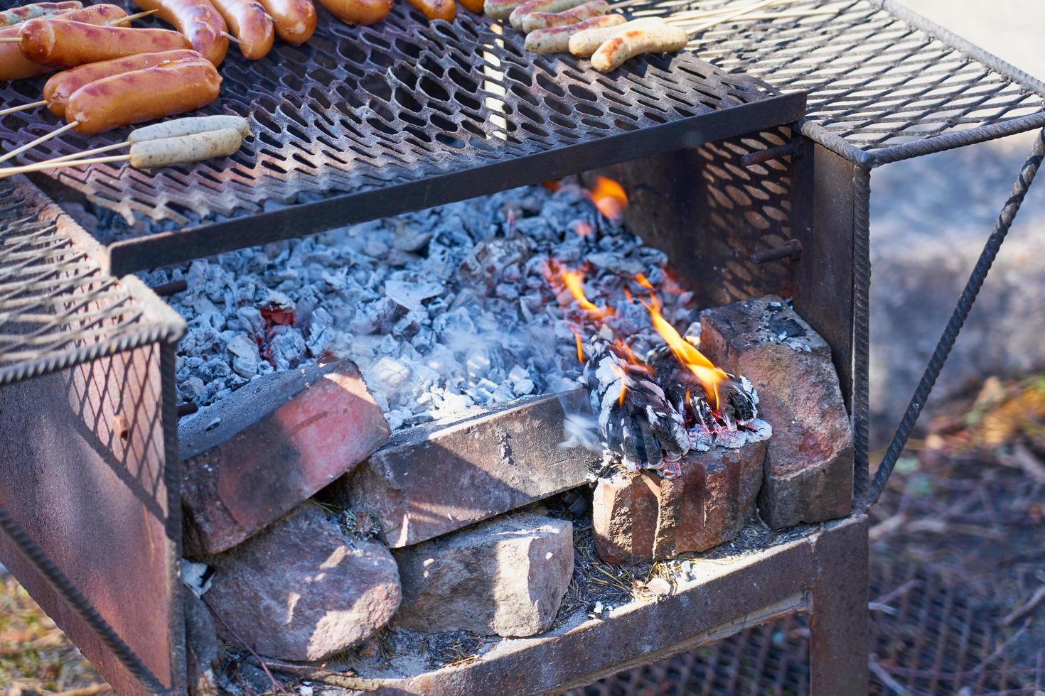 fuoco in una griglia vintage arrugginita all'aperto con sfondo sfocato foto