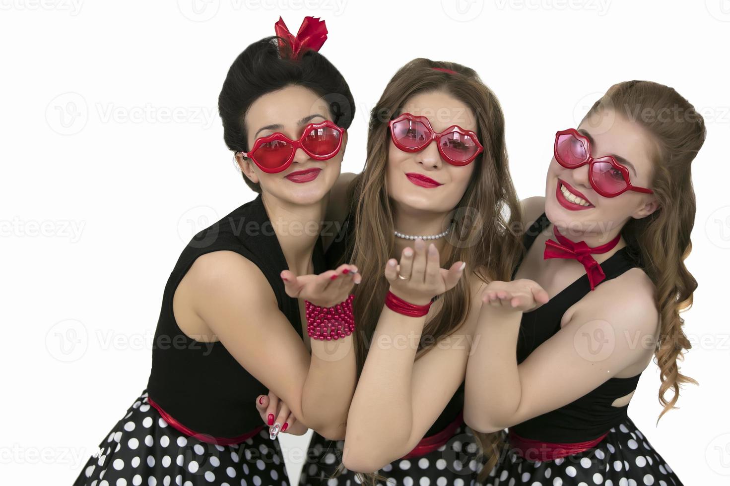 tre bellissimo retrò ragazze. un' gruppo di donne Spettacoli un aria bacio. foto