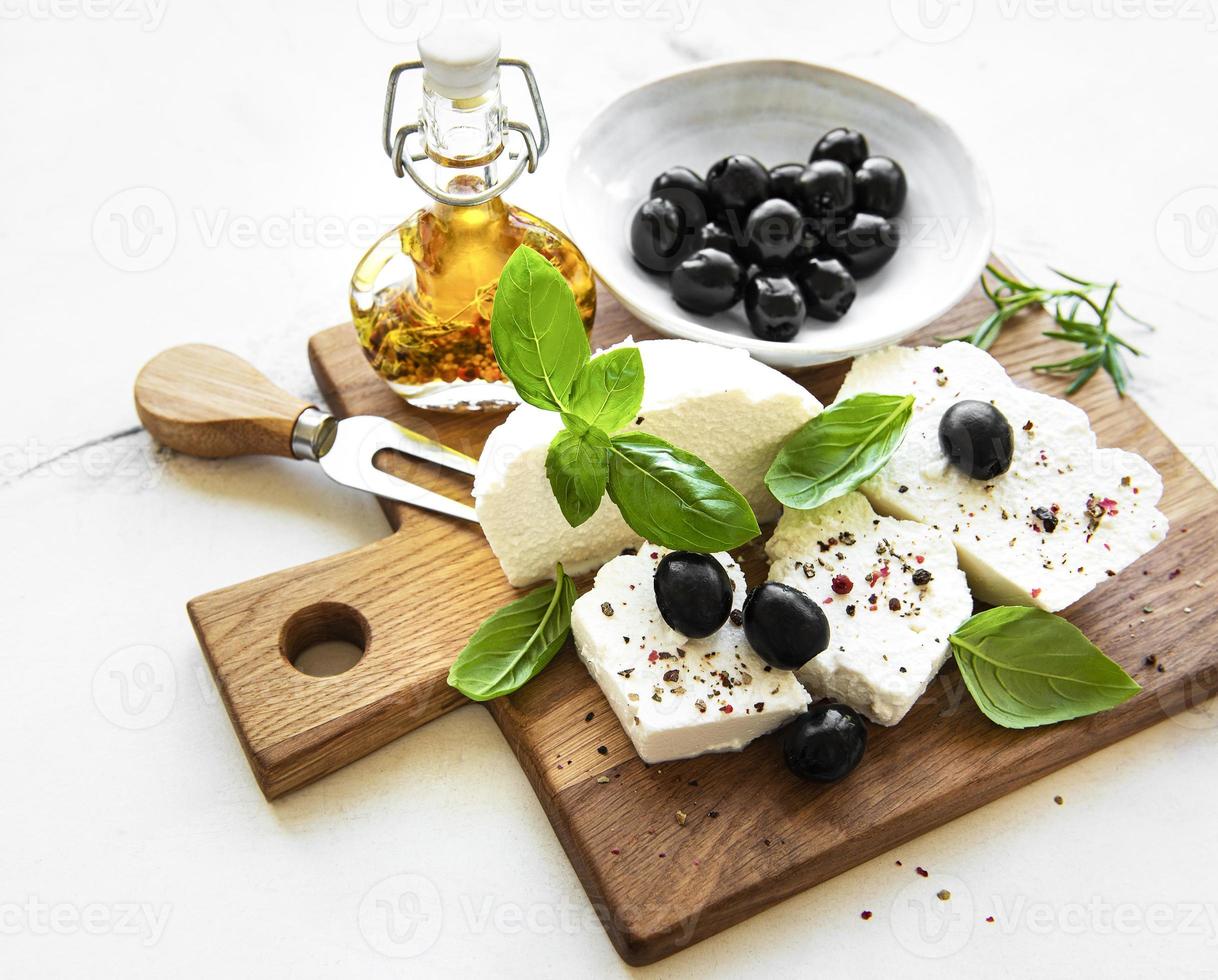 ricotta fresca con foglie di basilico e olive foto