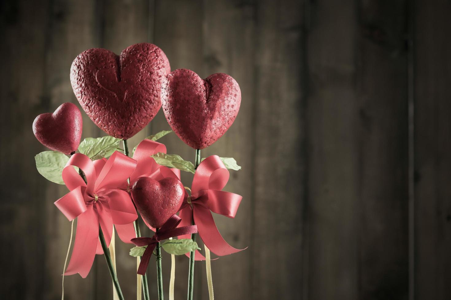 fiore nel il forma di cuore fatto a partire dal schiuma borad su Marrone legna sfondo foto