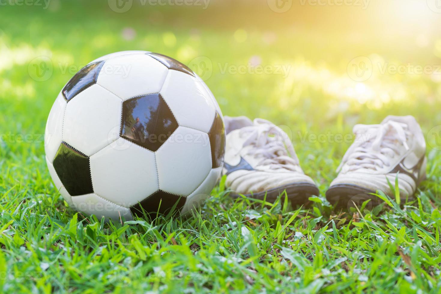 calcio su verde erba e perno scarpa con sole leggero foto