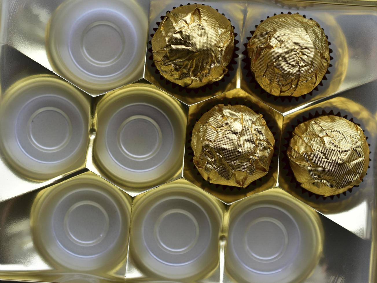 caramelle al cioccolato in una scatola in un involucro d'oro foto