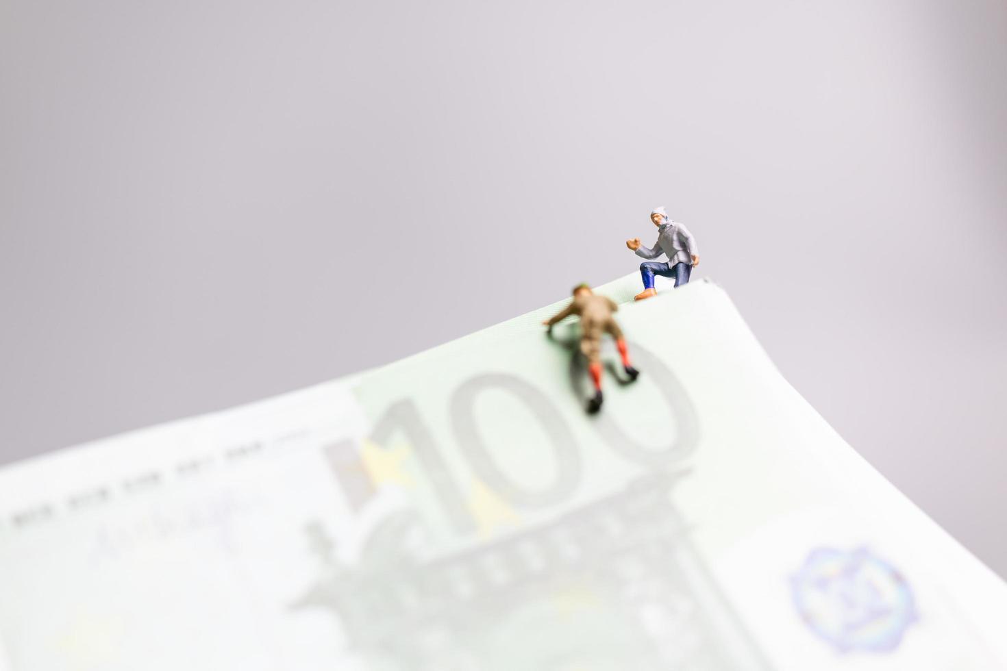 persone in miniatura, scalatore si arrampica su una banconota in euro, concetto di business. foto