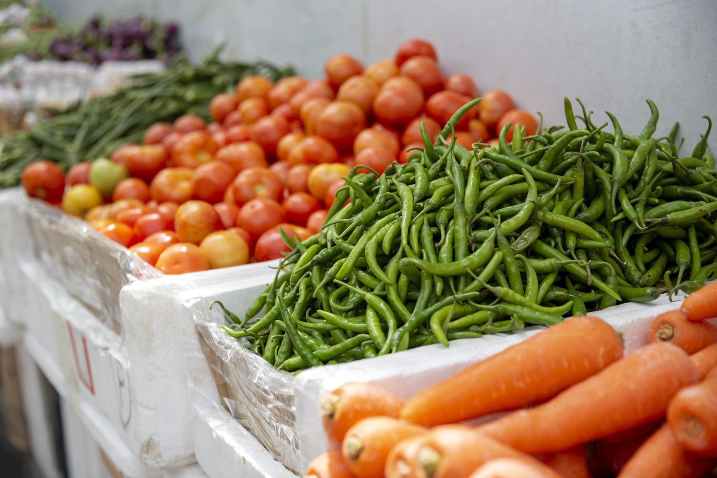 gruppo di pomodori freschi e sfondo di verdure biologiche nel mercato foto