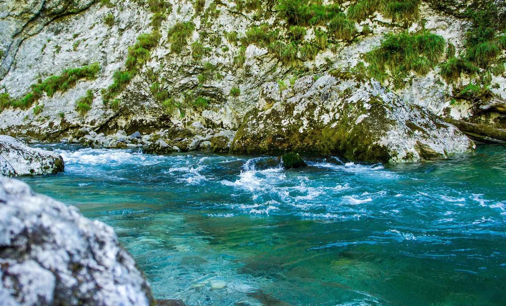 un fiume che scorre tra sponde rocciose accanto a una montagna foto